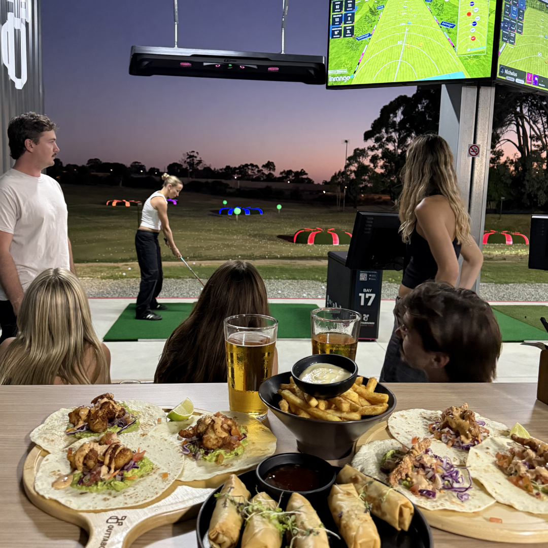 A group of friends playing on the driving range at OuttaBounds