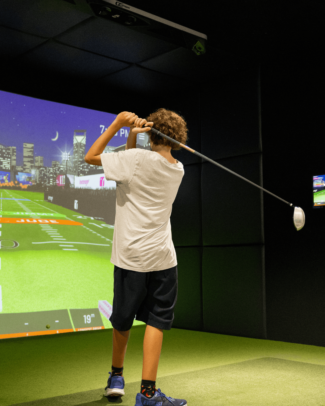 Teen playing on the golf sims at OuttaBounds Teen playing on the golf sims at OuttaBounds