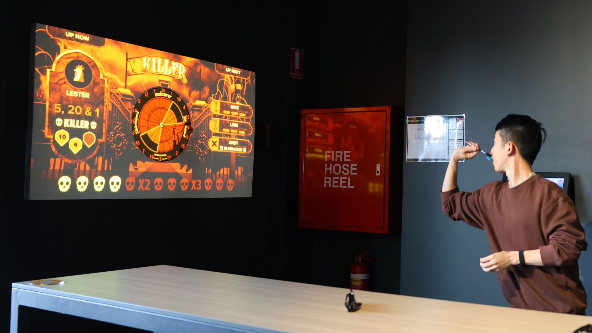 Young adult playing tech-driven interactive darts at OuttaBounds