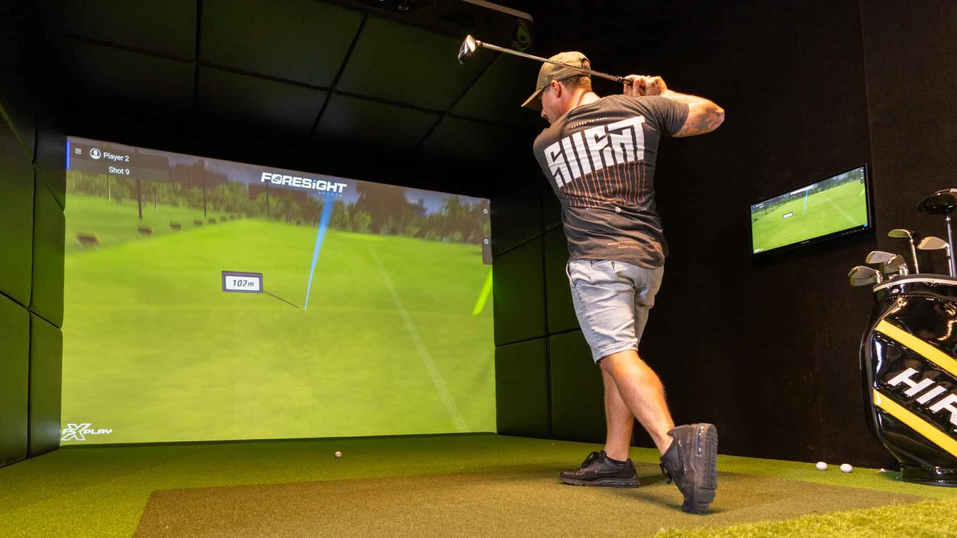 Man taking shot on tech-driven golf simulators
